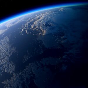 View of Earth from space highlighting the blue horizon, white clouds, and dark ocean.